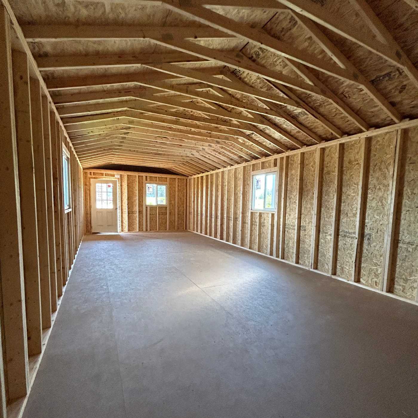 Interior of Premier gabled cabin showing framed walls, raised trusses and finished floor, ready to insulate